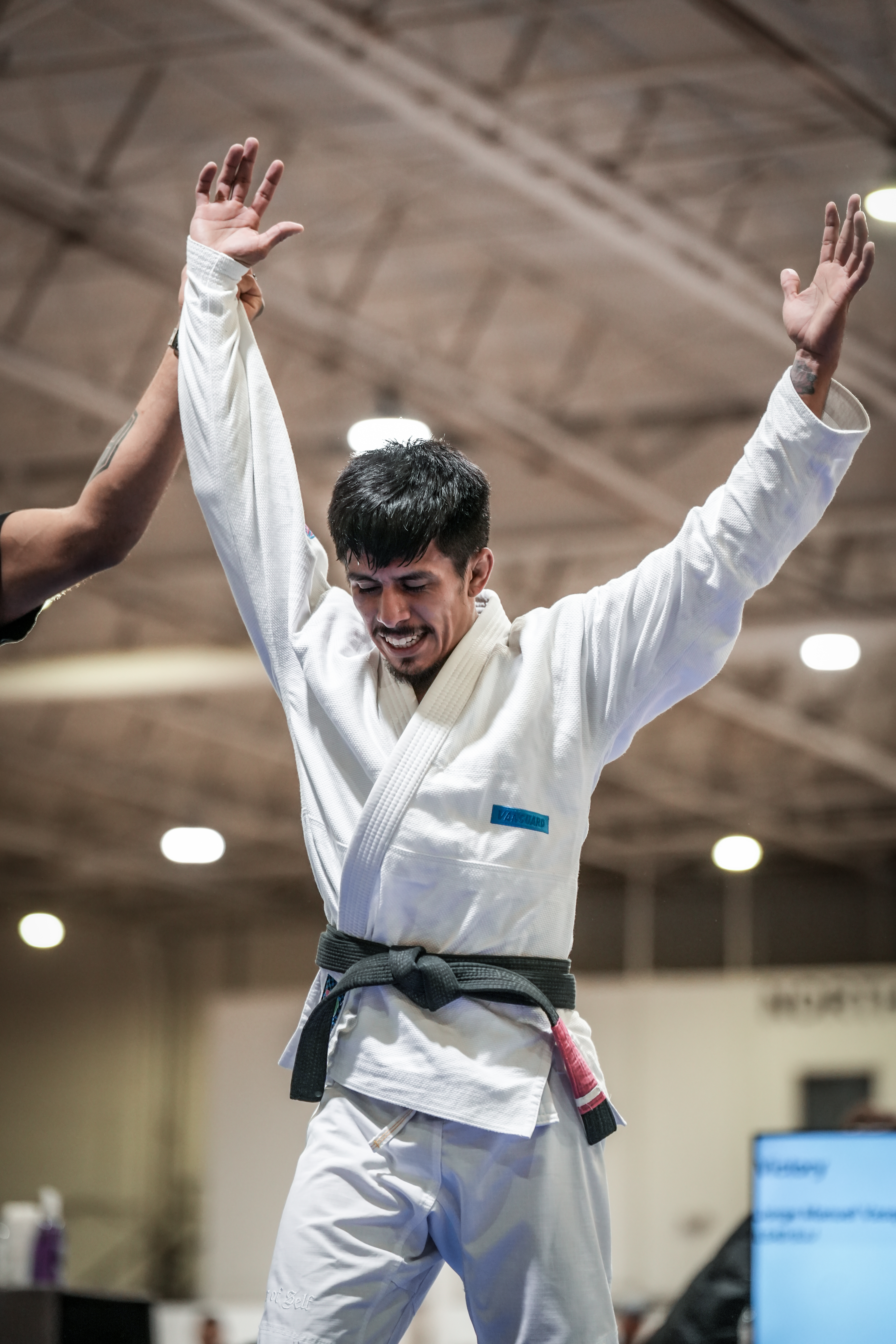 Black belt getting his hand raised after a tournament victory